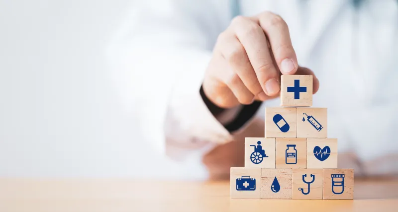 Drewniane klocki symbolizujące różne zakresy ubezpieczenia